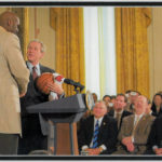 John Clark Sr looks on as President Bush shakes hands with Shaq.